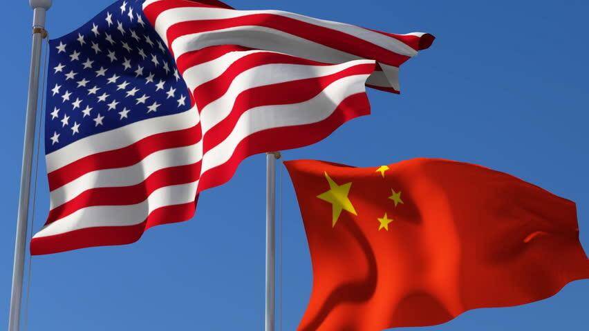Флаги США и Китая развевающиеся на фоне синего неба