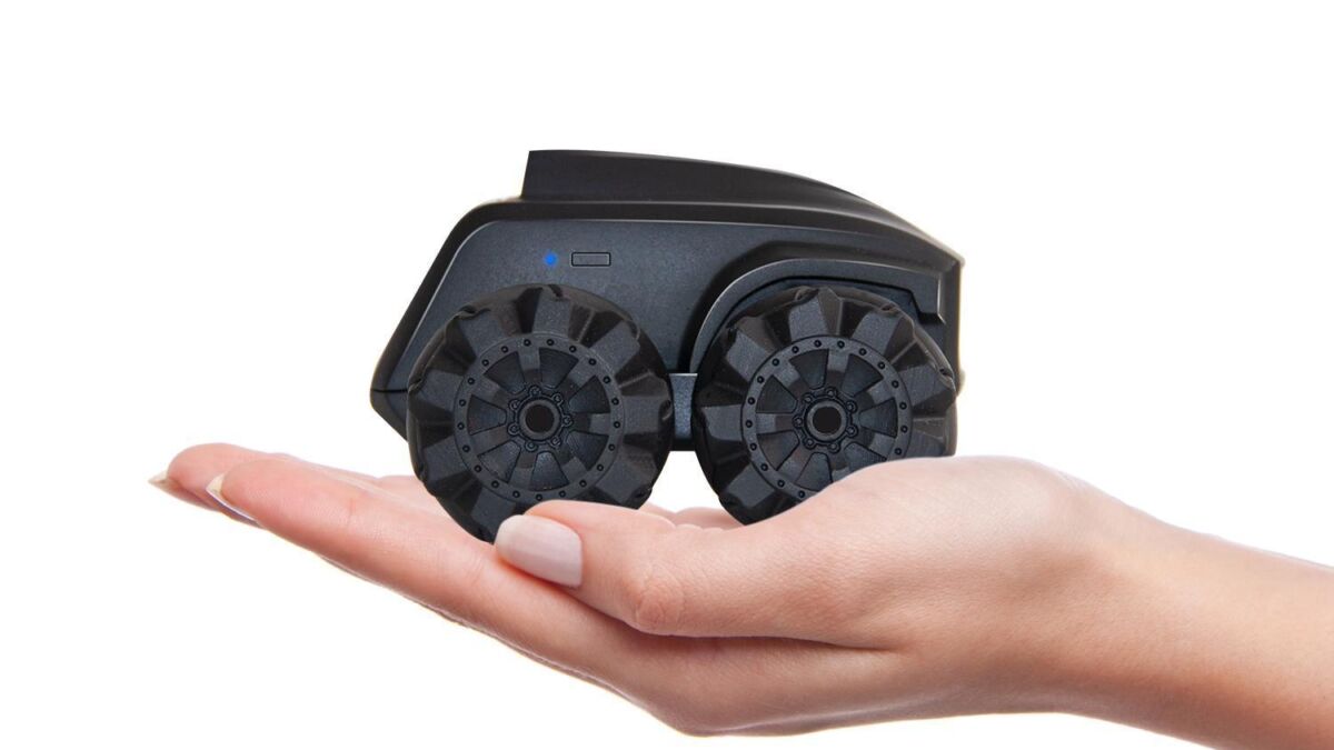 Ручная рука с моделью робота Scout с большими колесами