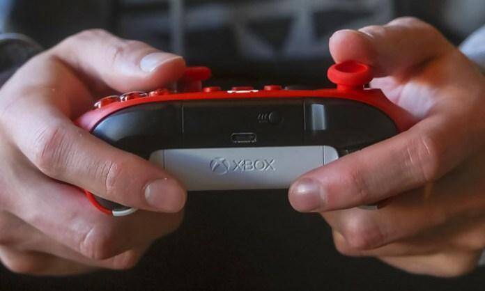 Microsoft представила новый геймад для Xbox в расцветке Pulse Red 5 Игровой контроллер Xbox Pulse Red в руке с боку