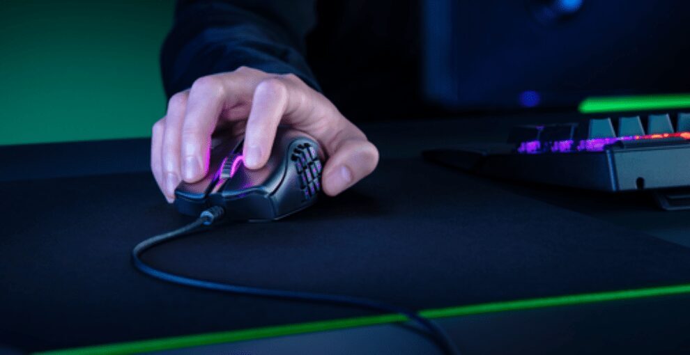 Игрок использует мышь Razer Naga X с RGB-подсветкой на игровом столе