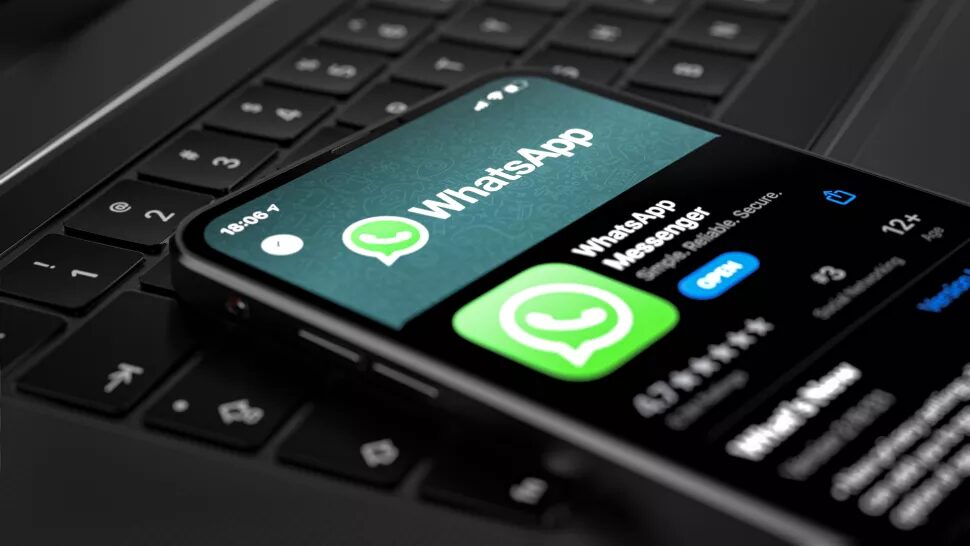 WhatsApp заявляет, что новая политика конфиденциальности никуда не денется 5 Смартфон с открытым приложением WhatsApp на клавиатуре ноутбука