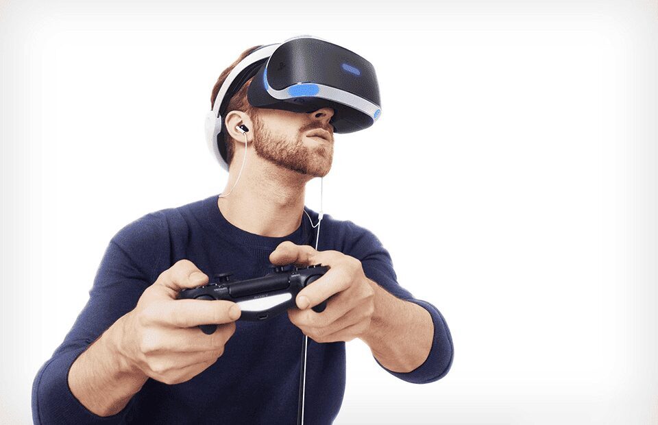 Человек с игровым контроллером и VR-шлемом для PlayStation 5