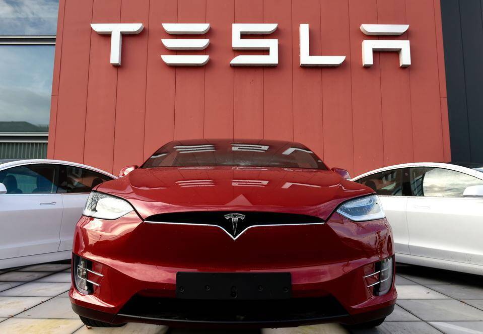 Красный Tesla Model S перед зданием Tesla магазина, вид спереди