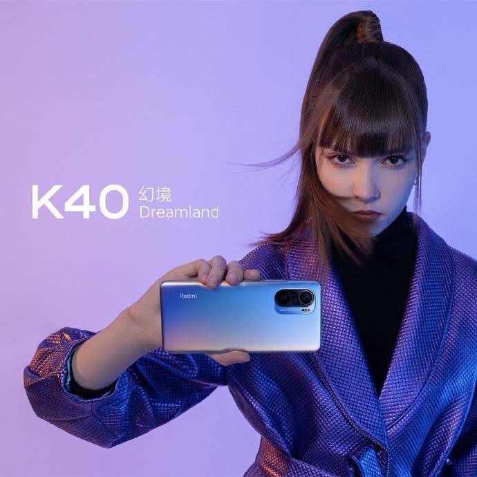 Redmi наконец-то представила смартфон Redmi K40 8 Фотография женщины с темными волосами и стильной одеждой, держащей смартфон Redmi K40 в руке