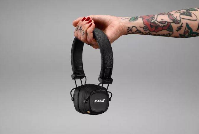 Чёрные наушники Marshall MAJOR IV в руке с татуировки