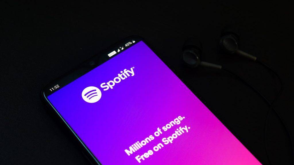 Экран смартфона с приложением Spotify с ярким градиентным фоном
