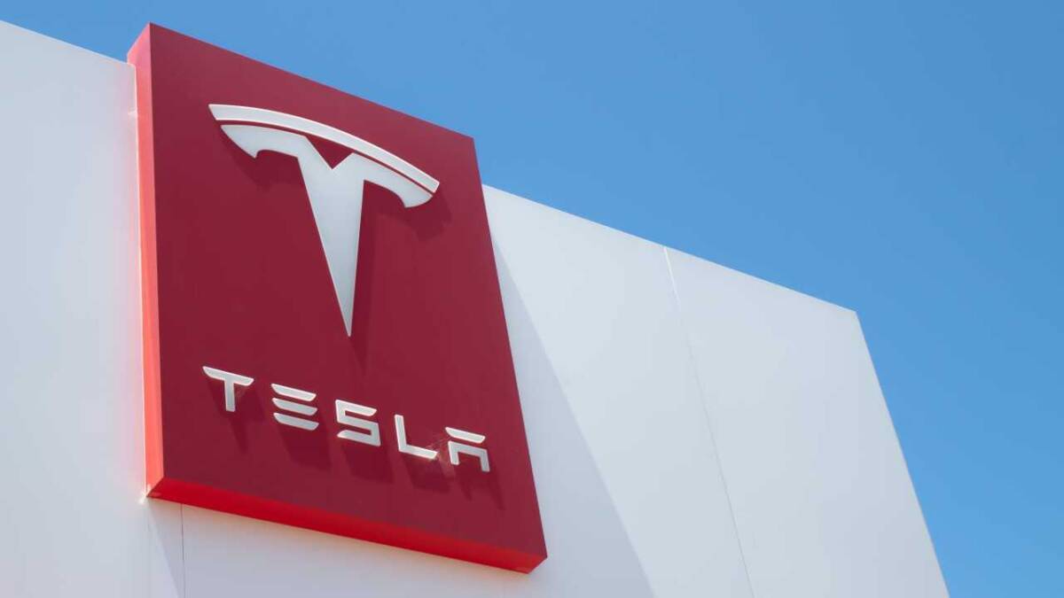 Логотип Tesla на фоне темы электромобилей и инвестиций в биткоин