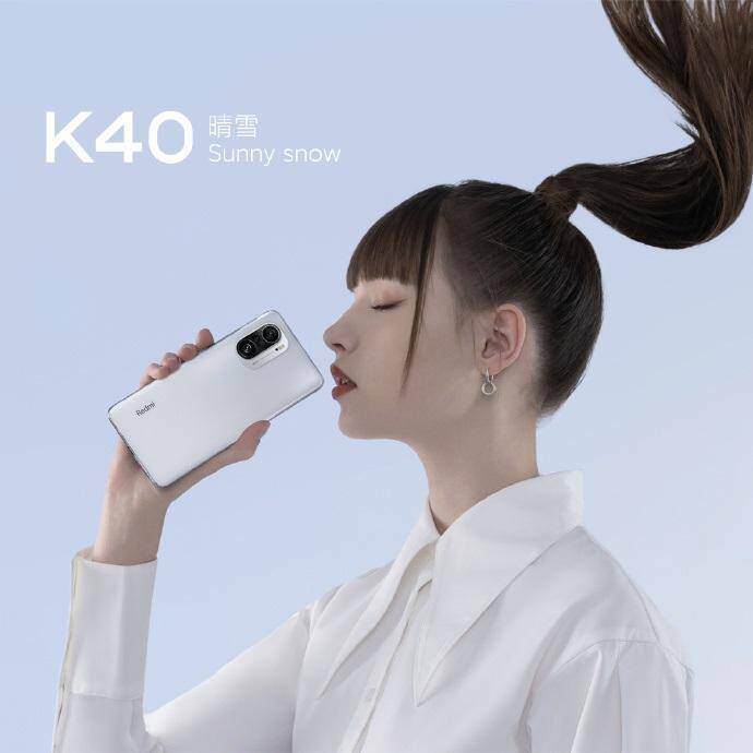 Redmi наконец-то представила смартфон Redmi K40 7 Женщина держит смартфон Redmi K40 с белым корпусом и крупной камерой сбоку