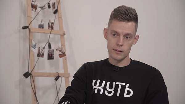 Минцифры собираются получать налоги с Instagram и YouTube за российских блогеров 3 Мужчина в черной футболке с русской надписью на фоне освещенной фотогалереи