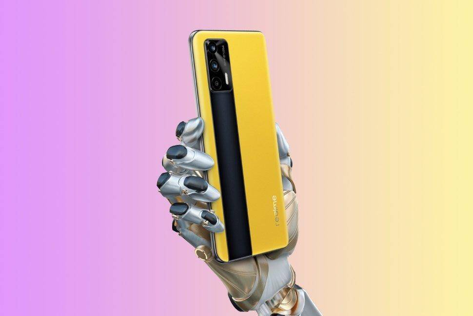 Желтая роботизированная рука держит смартфон realme GT от realme