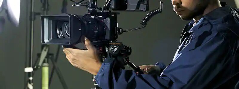 Оператор держит видеокамеру Sony Alpha 1 сбоку