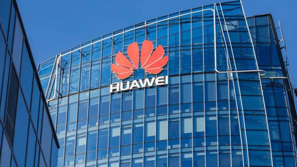 Логотип Huawei на стеклянной фасаде современного офисного здания в деловом районе