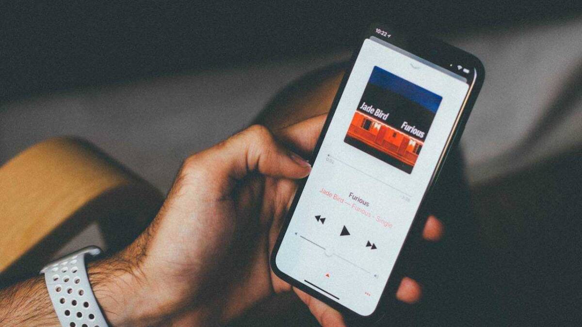 Экран смартфона Apple с музыкальным плеером и треком Furiously