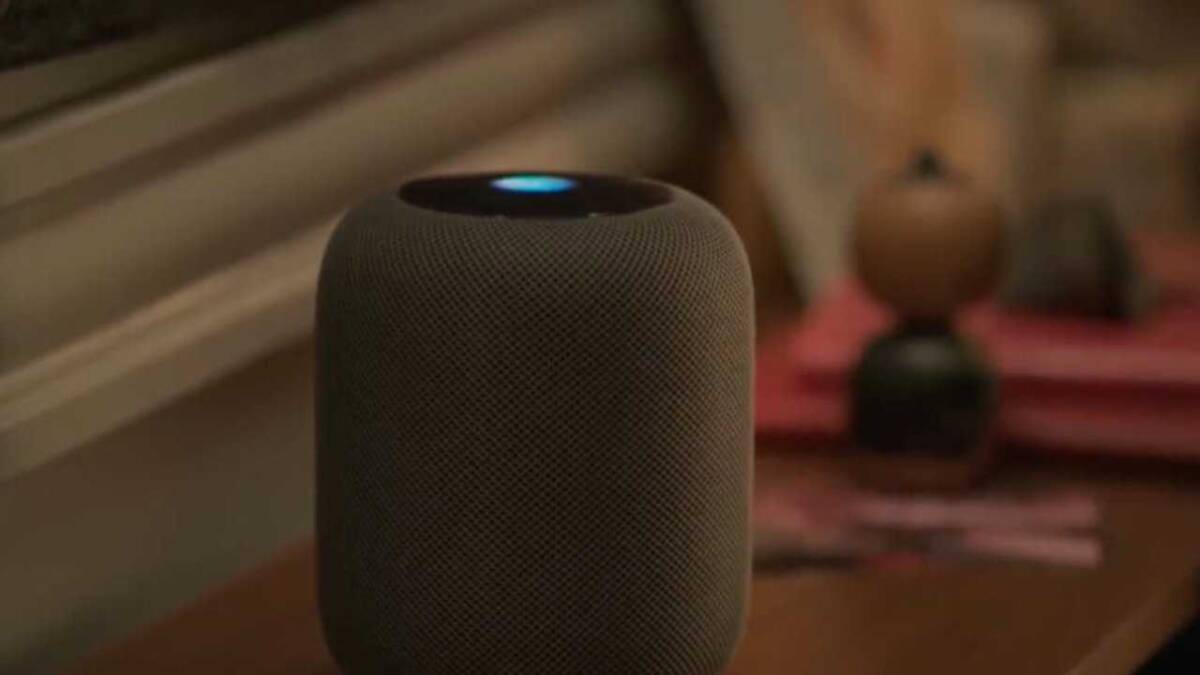 Колонка Apple HomePod мини на тумбочке в темной комнате