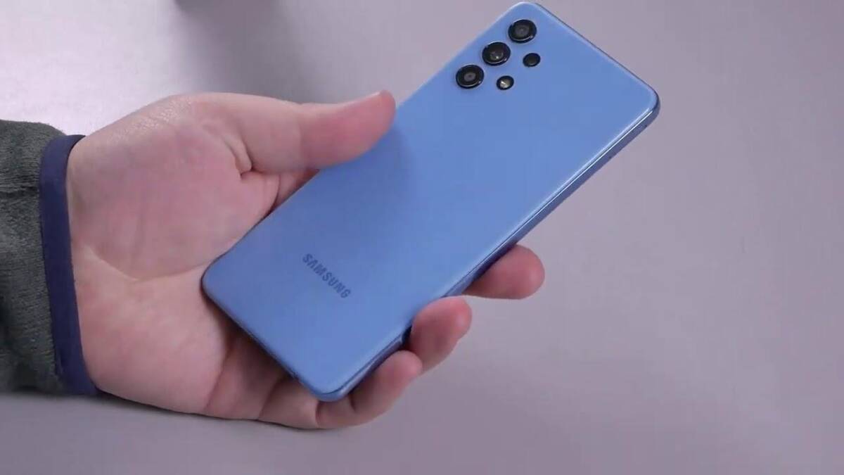 Серый смартфон Samsung Galaxy A32 в руке с задней стороны