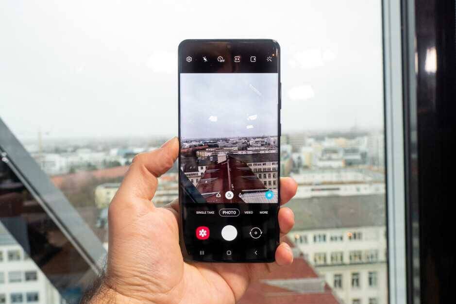 Смартфон Samsung Galaxy A72 делает фото через окно, пример режима фотосъемки на крыше здания