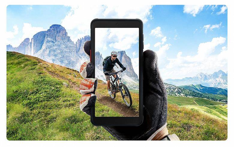 Защищённый смартфон Samsung Galaxy XCover 5 с камерой ярко освещён в руках