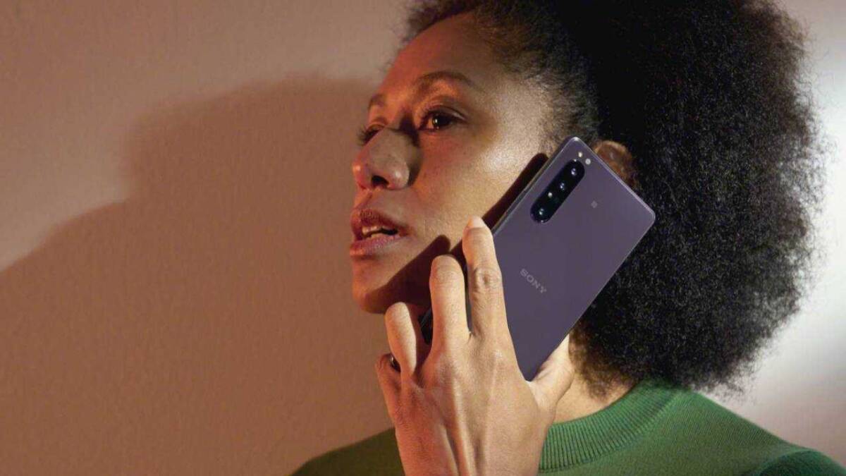 Женщина держит смартфон Sony Xperia 10 III у головы крупным планом