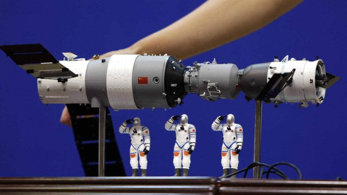 Макет китайской орбитальной станции Tiangong-1 на выставке с миниатюрами астронавтов