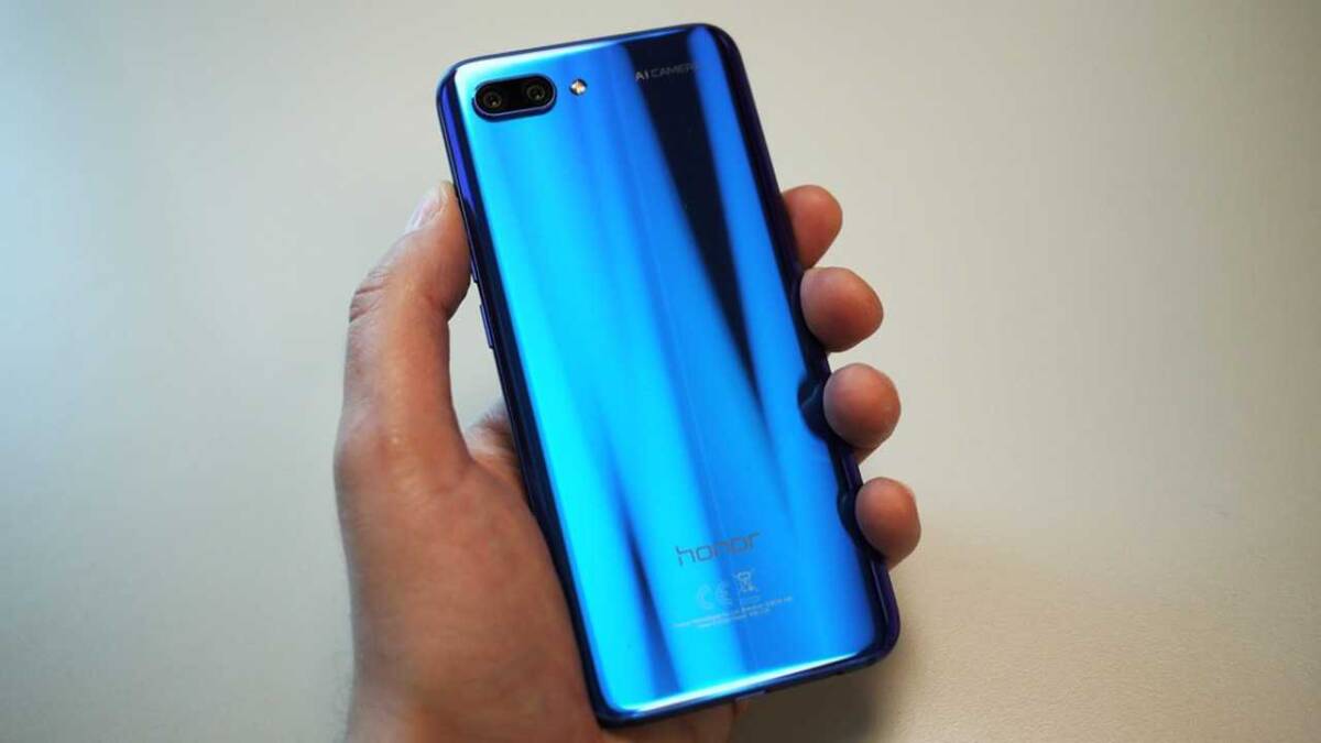 Рука держит синий смартфон Honor с двойной камерой