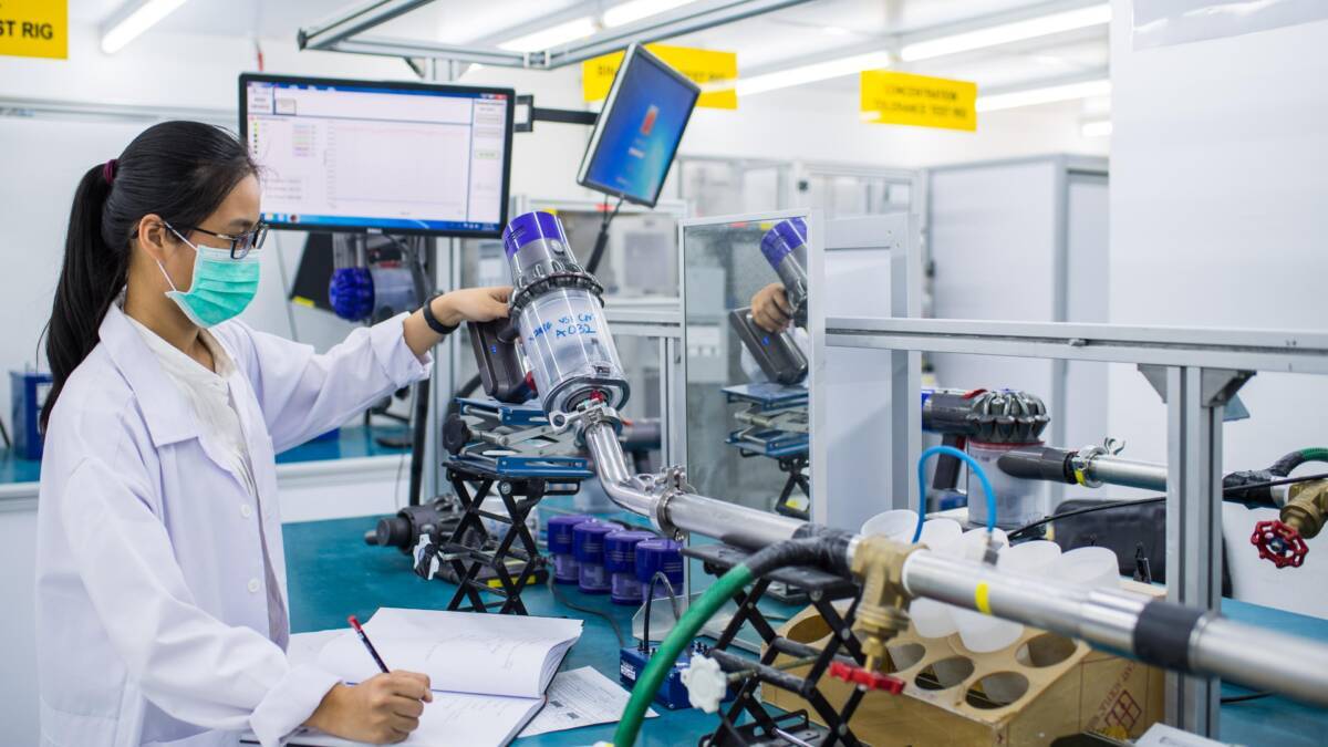 Лабораторные исследования Dyson: работник обслуживает вакуумный насос Dyson в процессе тестирования технологий