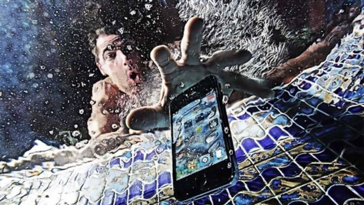 Мужчина тянется к воде с защищенным смартфоном Samsung Galaxy S8 в брызгах
