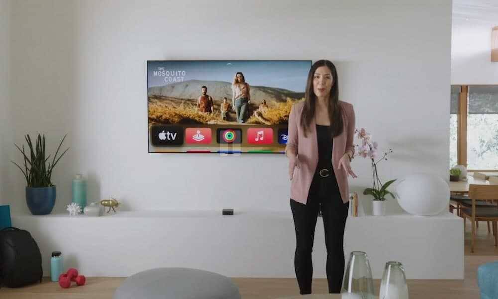 Женщина стоит перед телевизором Apple TV 4K в гостиной