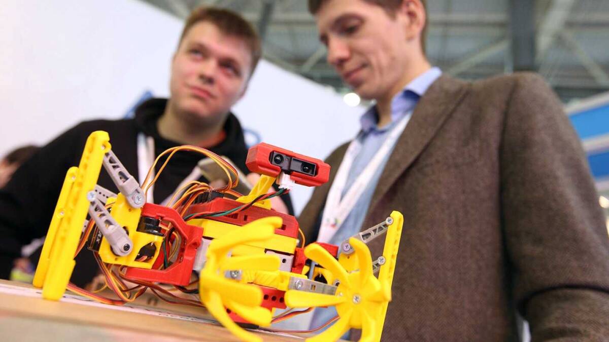 Робот DJI RoboMaster Youth с желтыми и красными деталями на столе на выставке в Москве