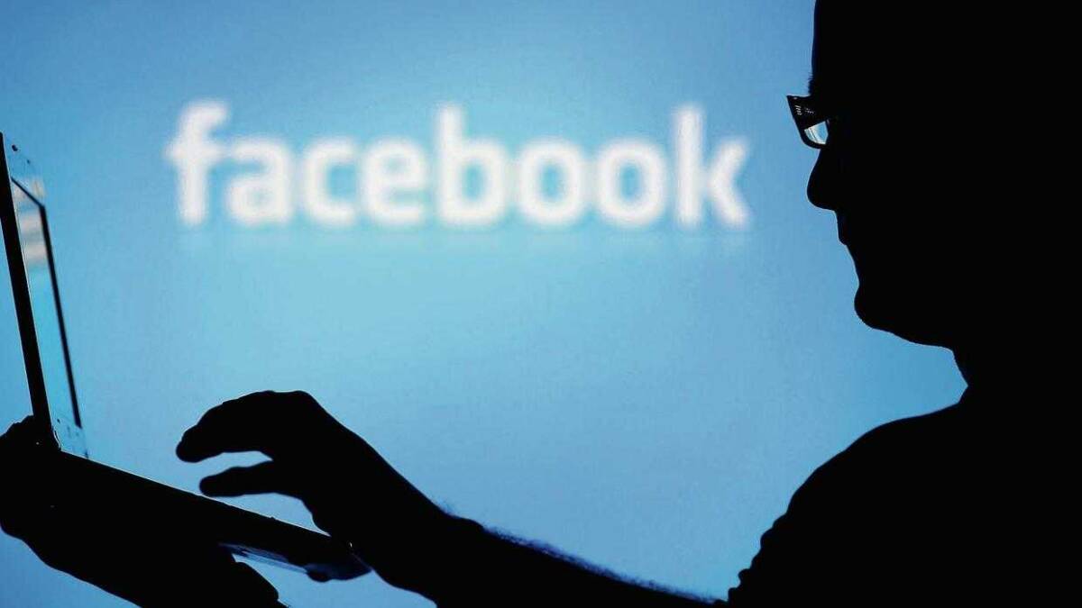 Facebook рассказала о причине масштабной утечки данных 4 силуэт человека с планшетом перед экраном с логотипом Facebook*