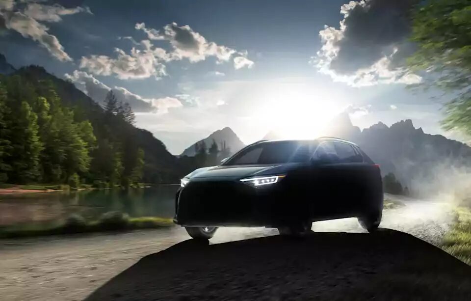 Электромобиль Subaru на дороге у озера и гор
