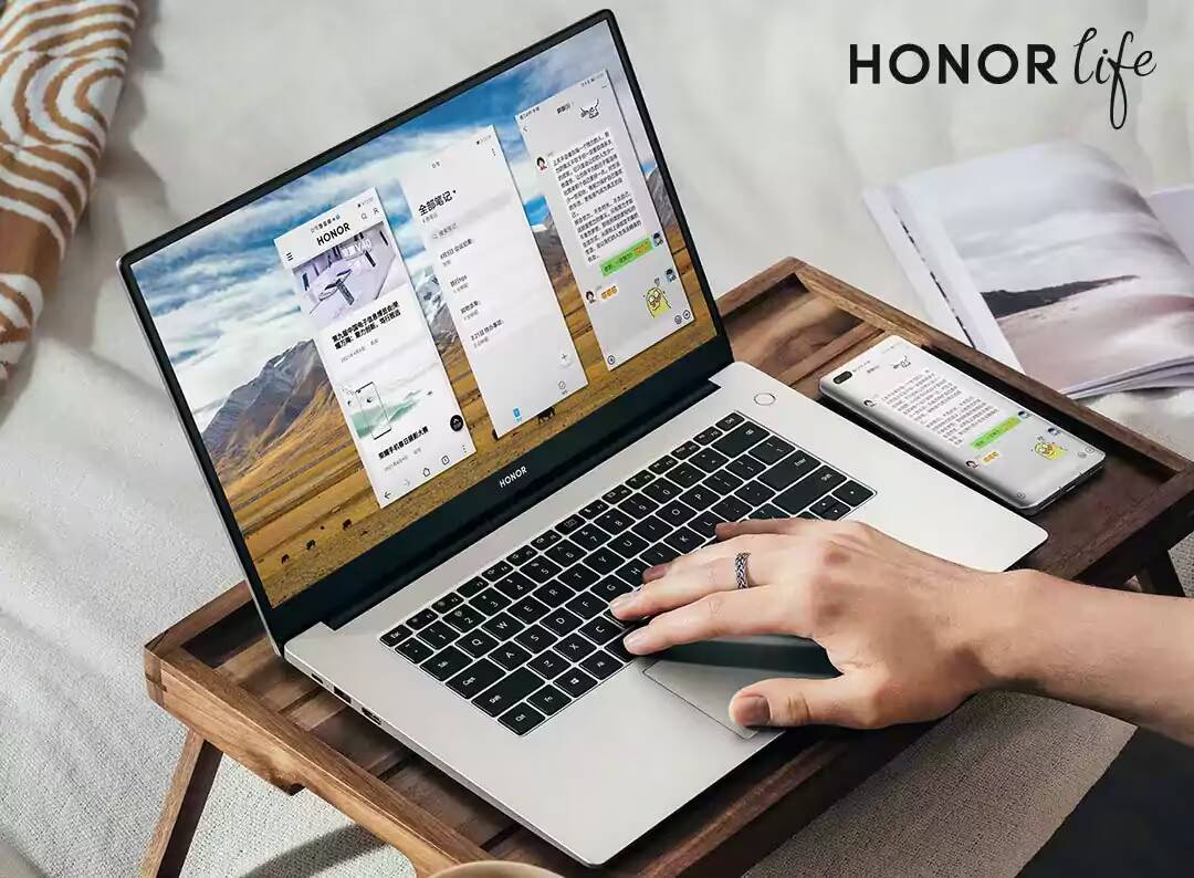 Honor выпустила новые версии ноутбуков MagicBook X 14 и MagicBook X 15 2 Ноутбук Honor MagicBook X 14 с открытым экраном и клавиатурой на деревянной поверхности