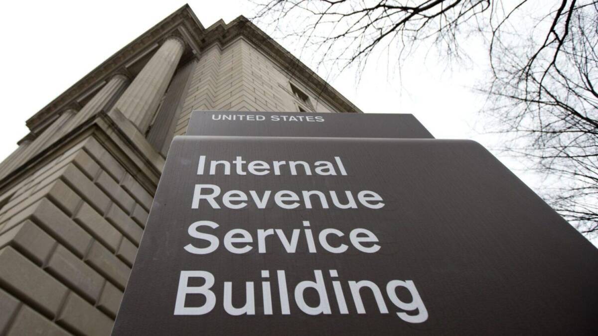Здание IRS США и вывеска вблизи офиса — указатель на внутреннюю налоговую службу