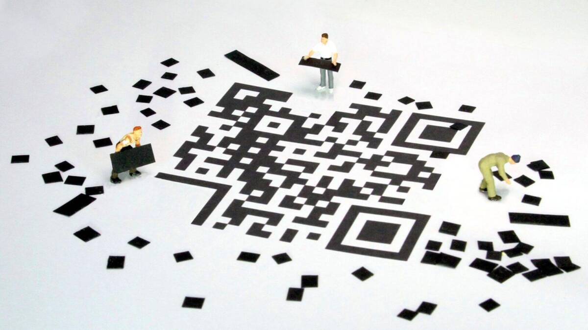 миниатюрные фигуры людей с бумажным QR-кодом и штрих-кодом