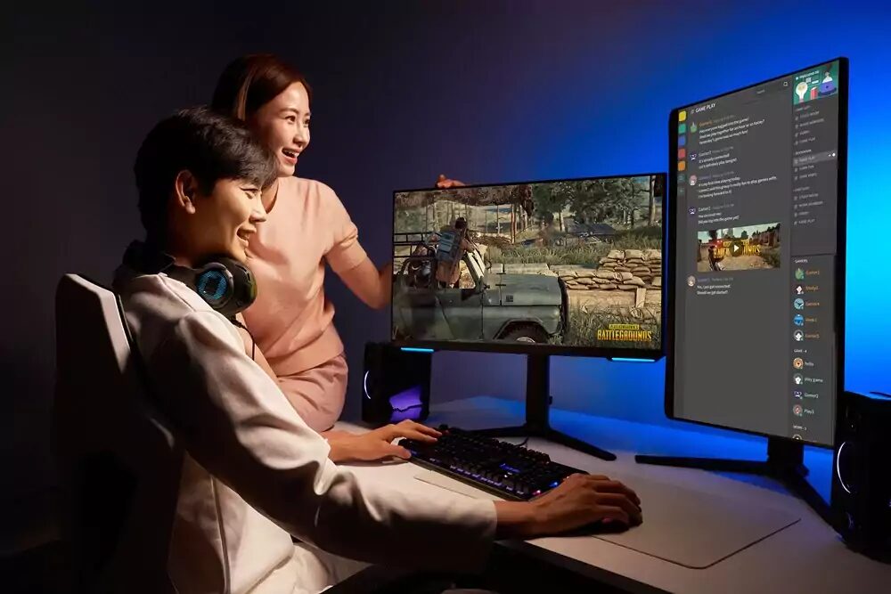 Два человека за игровой монитор Samsung Odyssey в темной комнате