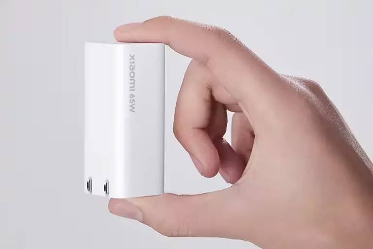 Белый зарядный блок Xiaomi 65 Вт в руке