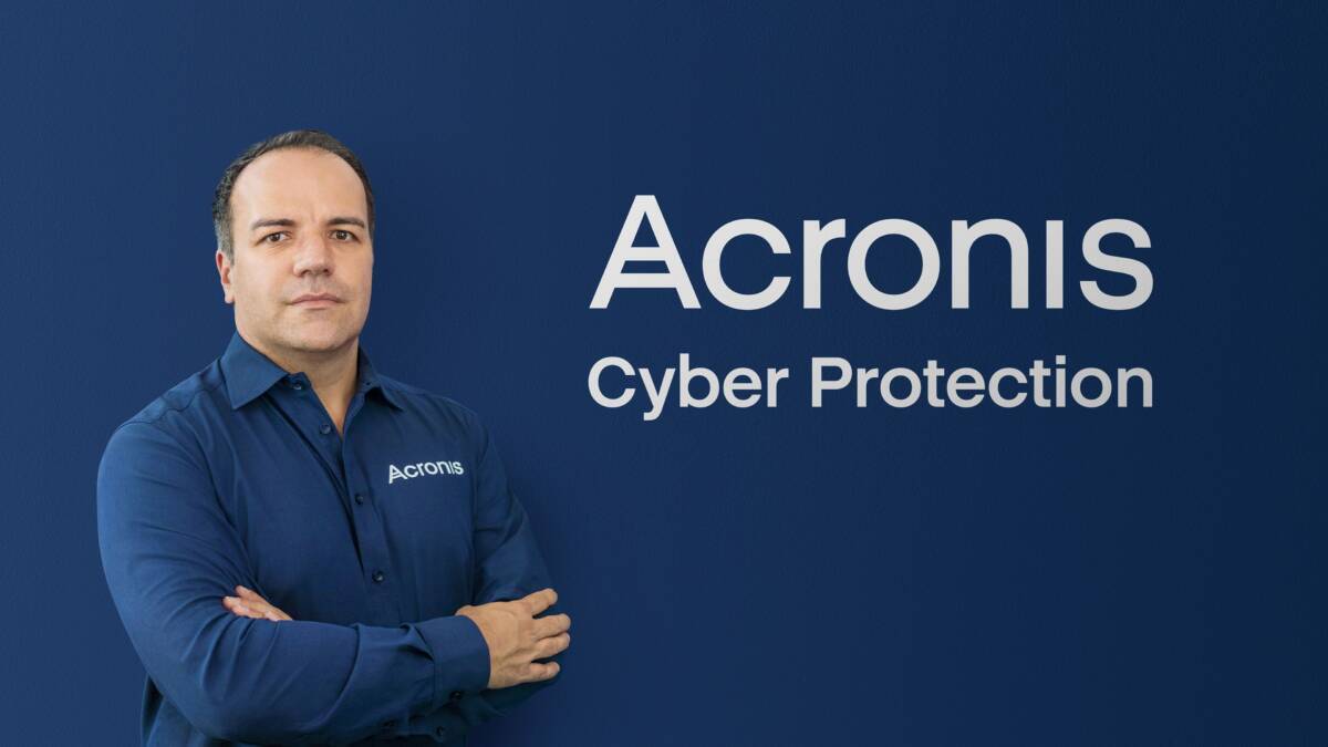 Представитель Acronis в синей рубашке с логотипом на фоне фирмы, фото Патрика Пульвермюллера