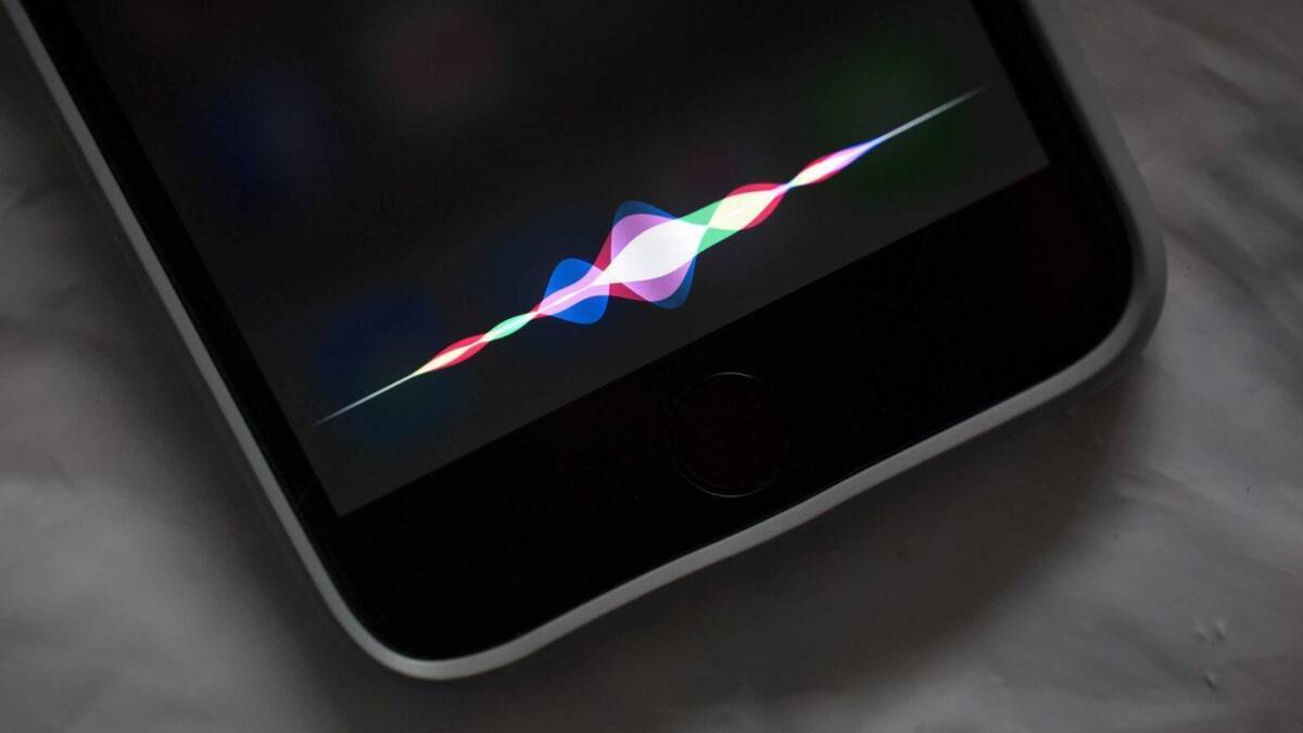 Экран iPhone с интерфейсом Siri: отклик голосового ассистента на черном фоне