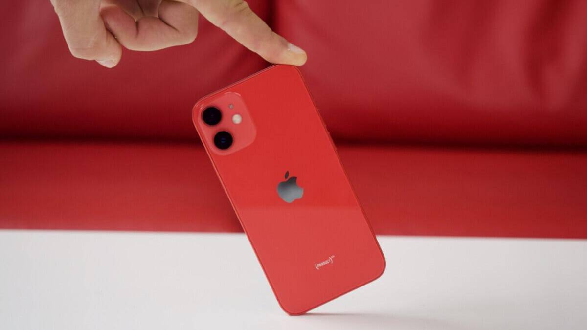 Красный iPhone 13 mini с двойной камерой на задней панели и логотипом Apple