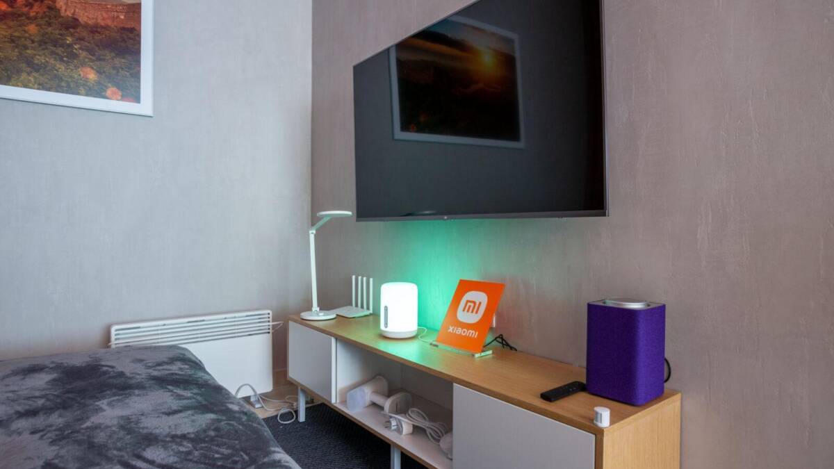 Гостиная в Москве: телевизор и умная техника Xiaomi на тумбе, лампа и колонка