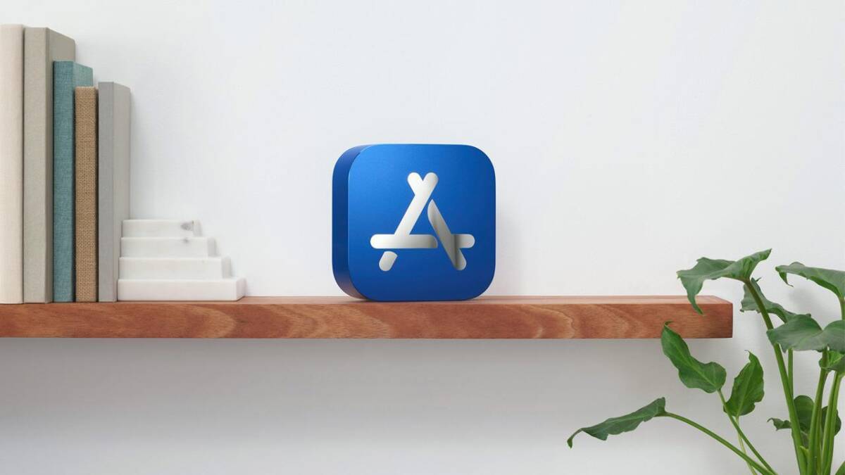 Иконка App Store на деревянной полке рядом с книгами и растением