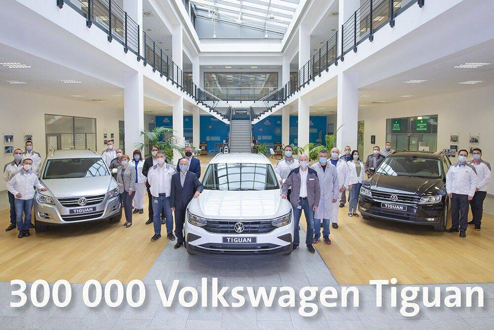 300 000 Volkswagen Tiguan произведено в России 3 Коллектив сотрудников у трех автомобилей Volkswagen Tiguan в офисе