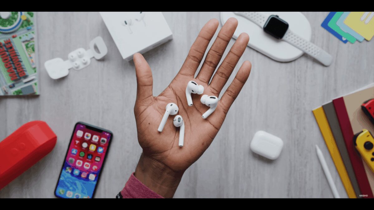 Беспроводные наушники AirPods в руке на столе