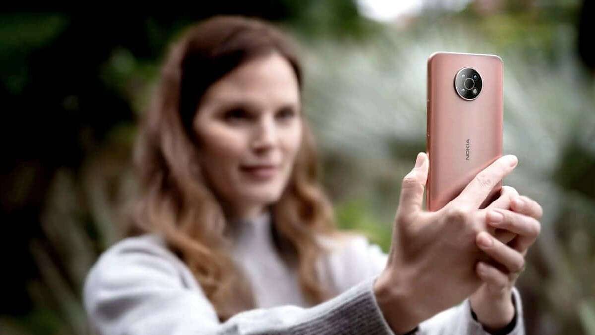 Женщина делает селфи на смартфон Nokia G50 на улице