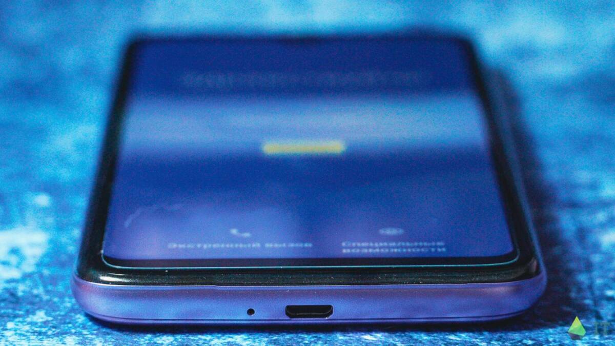 смартфон Itel A48 на поверхности синий фон