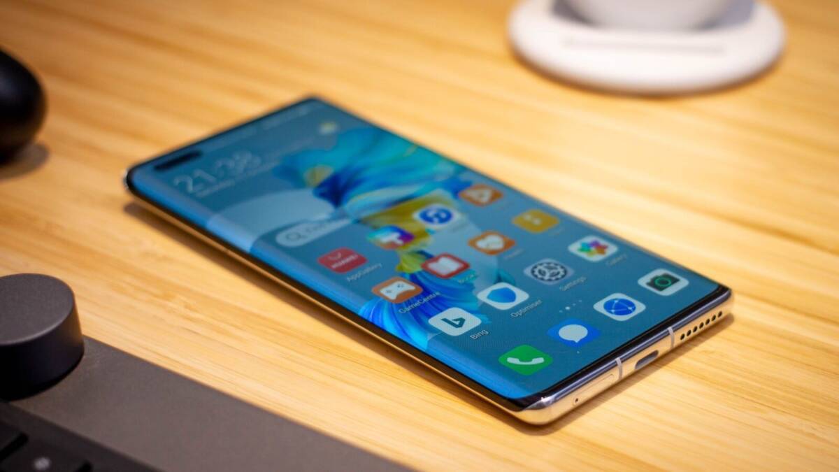 Смартфон Huawei Mate 50 на деревянной поверхности: экран с интерфейсом и приложениями