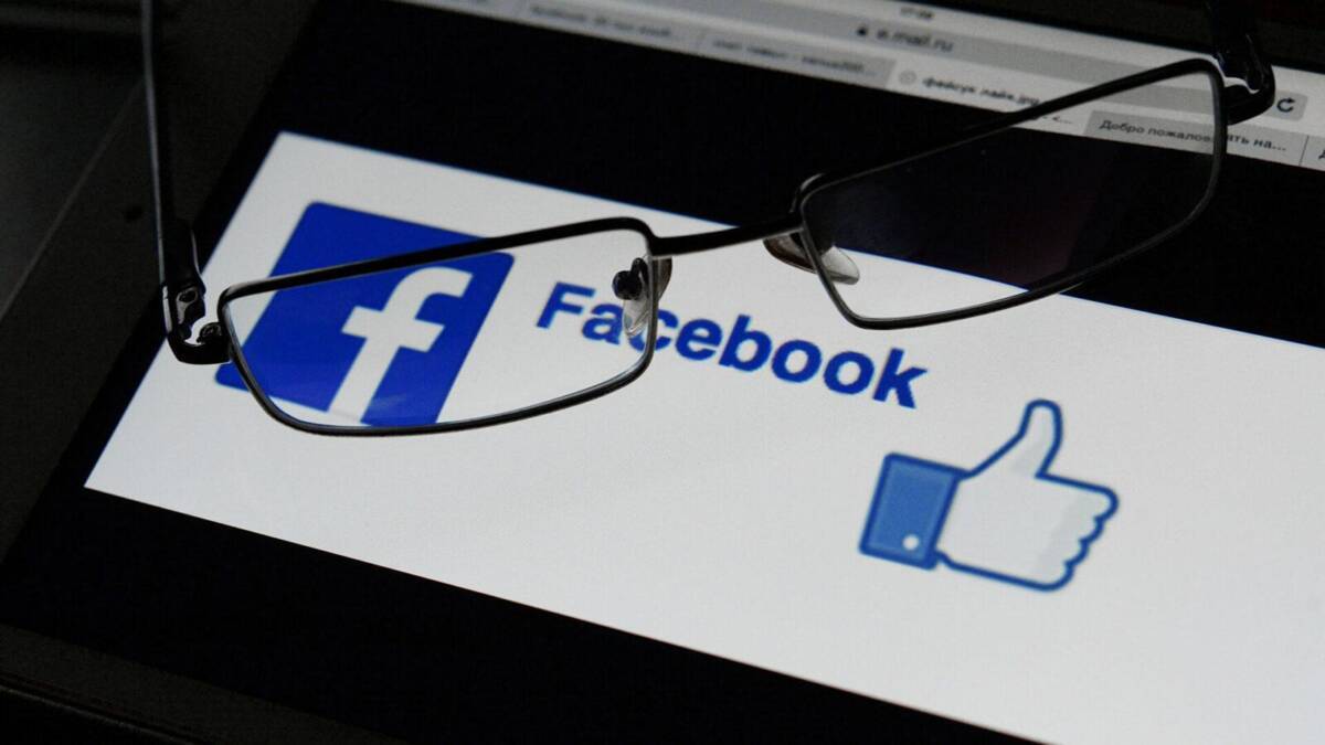 Экран смартфона с логотипом Facebook и иконкой лайка