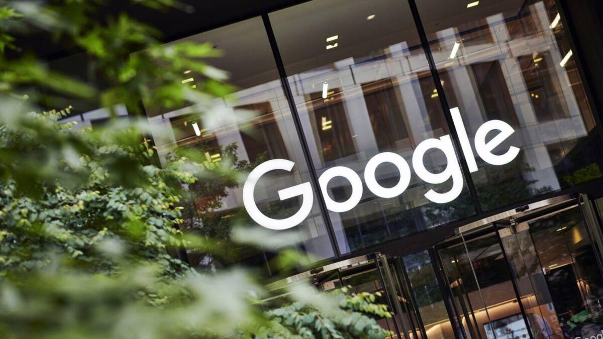 Здание Google на улице с логотипом на фасаде и отражениями в стеклянных окнах