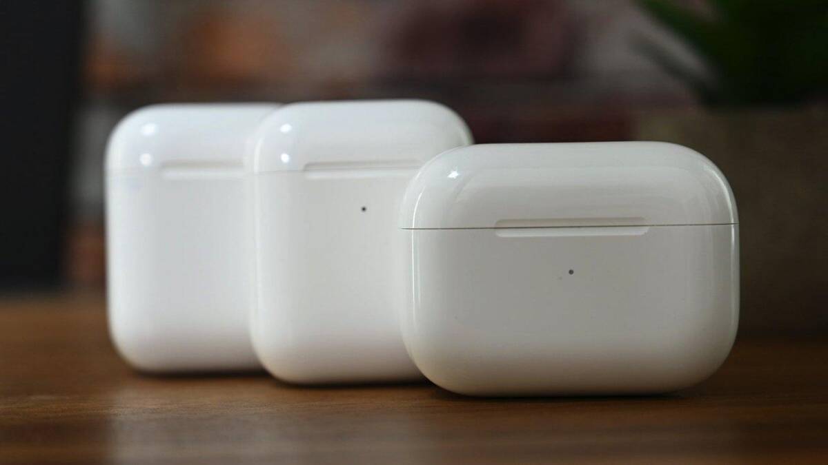 Четыре блистера наушников AirPods на деревянной поверхности