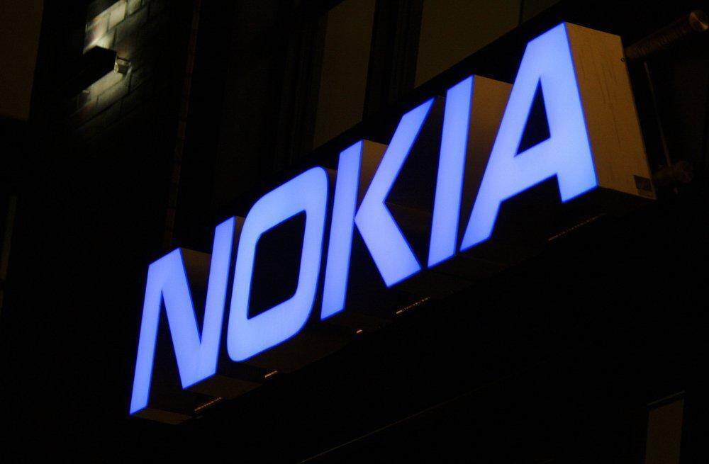 вывеска с синим светящимся логотипом Nokia на темном фоне