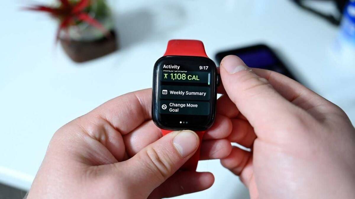 Рука держит умные часы Apple Watch с экраном активности